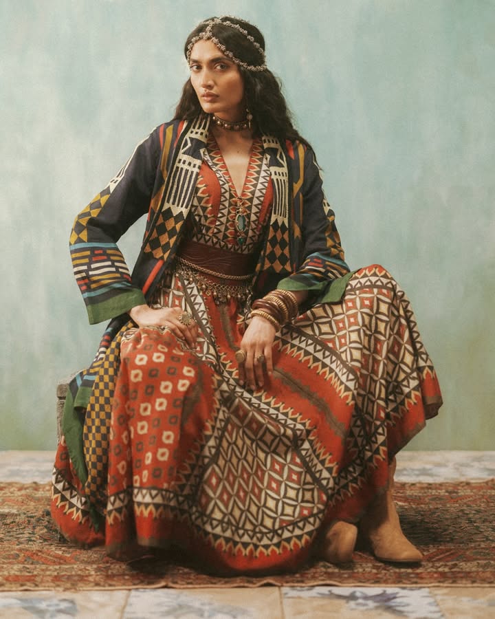Featuring complex prints constructed from simple geometric shapes, this look brings together a maroon chanderi long dress wi...