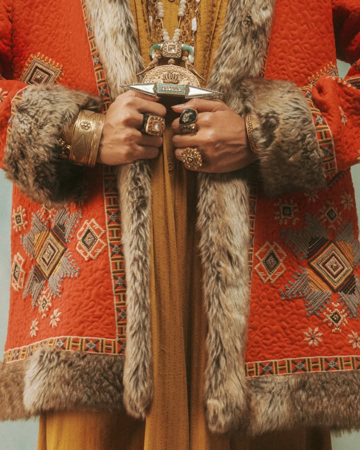 Crafted with suede, this red jacket is adorned with raised geometric patterns and motifs