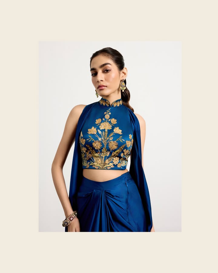 A sapphire hued saree paired with a statement top, this ensemble features contrasting motifs inspired by Parisian wooden art...